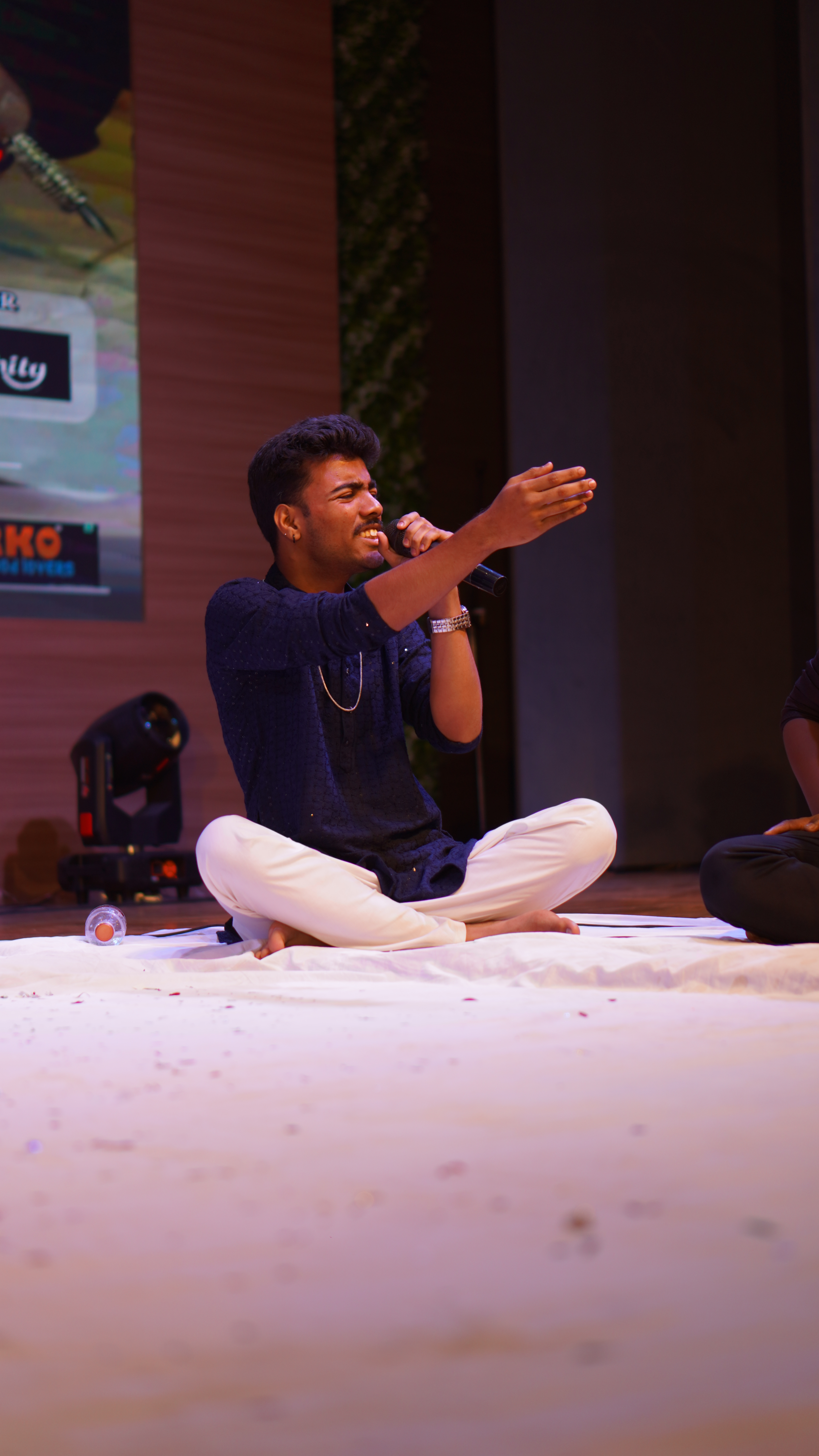Grandstand 5.0 Grand Finale — Dr. Arvinder Kaur presiding over the judged open mic rounds.